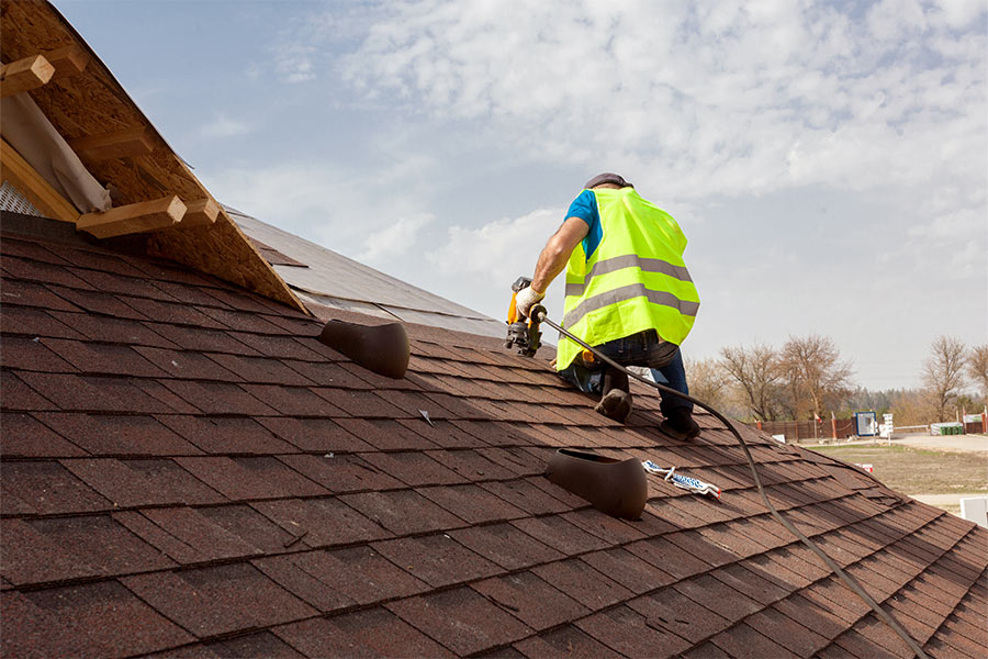 roofer with nail gun on roof